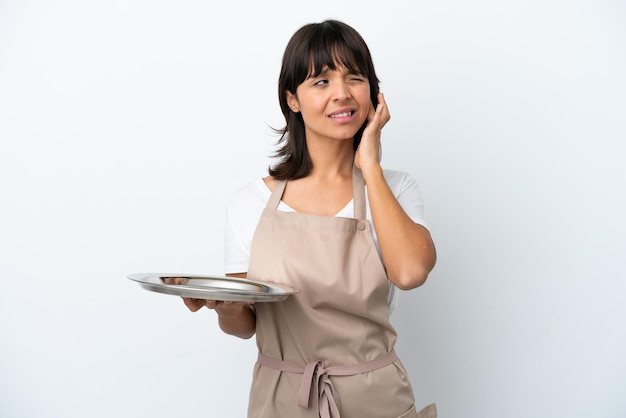 Young waitress with tray isolated on white background frustrated and covering ears