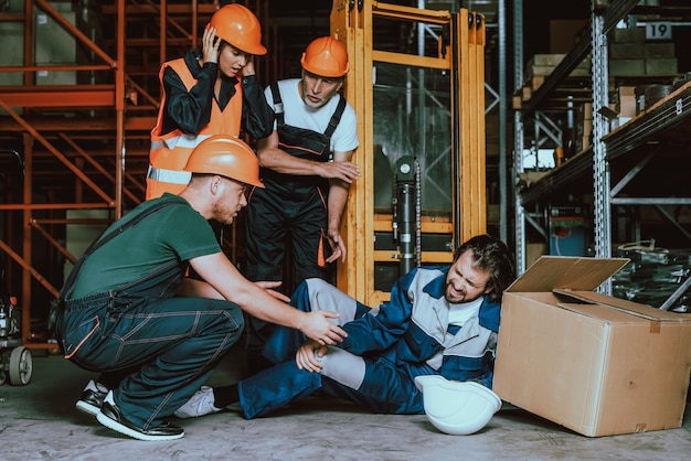 Foto gamba danneggiata del giovane lavoratore del magazzino nel luogo di lavoro