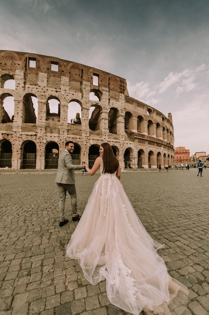 ローマ、イタリアのコロシアムで若い結婚式のカップル