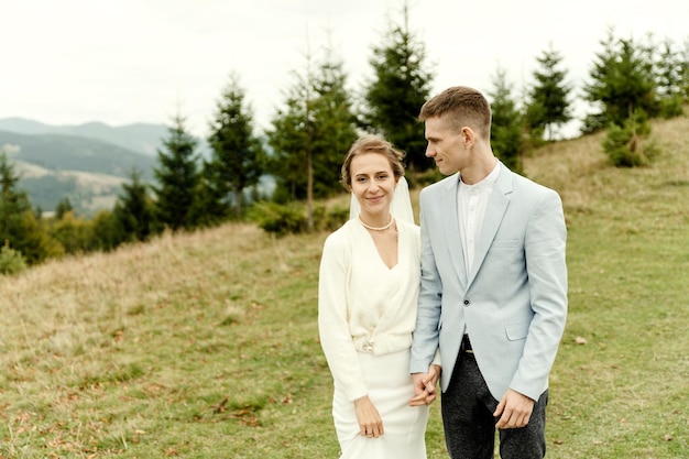 Young wedding couple gently hugging after the wedding ceremony in the mountains beautiful wedding day