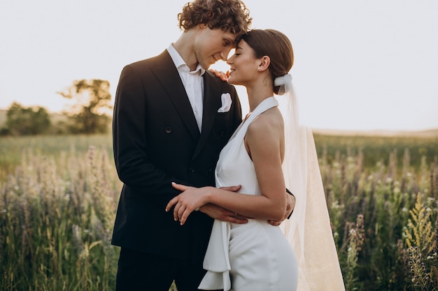 Photo young wedding couple together in field