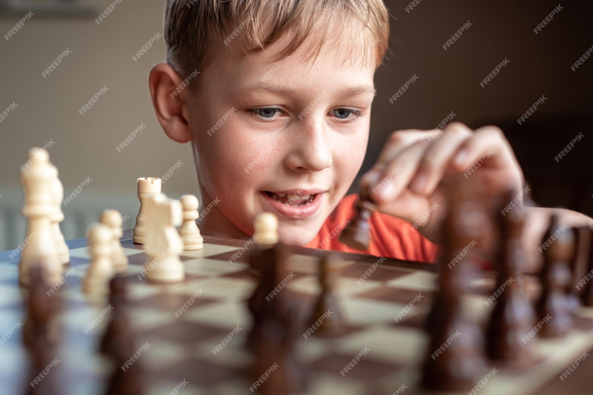 Premium Photo  Young white child playing a game of chess on large chess  board chess board on table in front of school boy thinking of next move