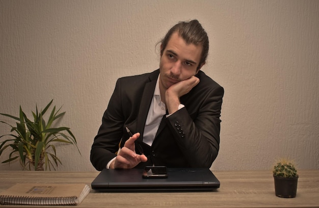 Фото Молодой белый мужчина-предприниматель в домашнем офисе думает