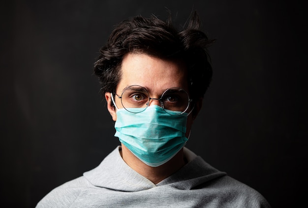 Young white man in glasses and protective mask