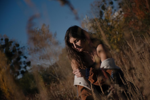 Young, wind and free girl in boho clothes walks in the forest.