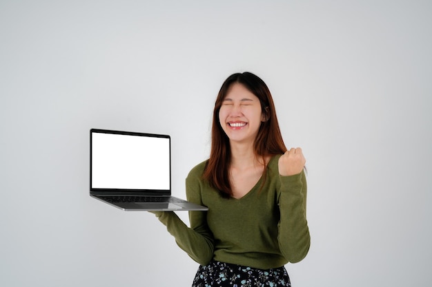 Young winner asian girl holding a laptop with show blank white sreen isolated on white background