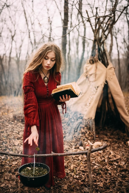 Young witch in the autumn forest