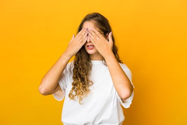 Photo young woman afraid covering eyes with hands