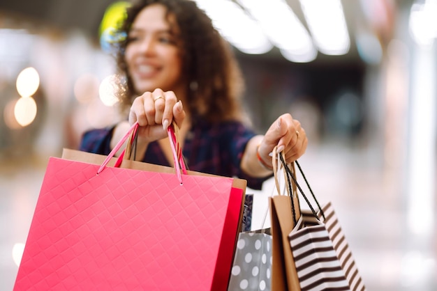 Young woman after shopping with shopping bags walks in the mall Spring shoopping