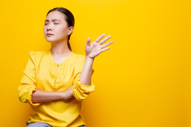 Young woman against yellow background