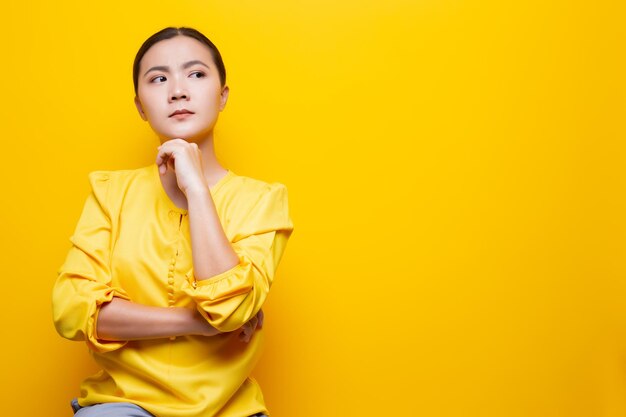 Young woman against yellow background