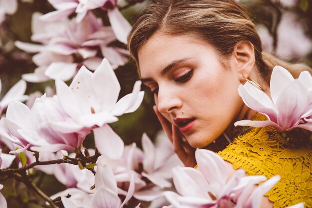 Photo young woman amidst pink flowers during springtime