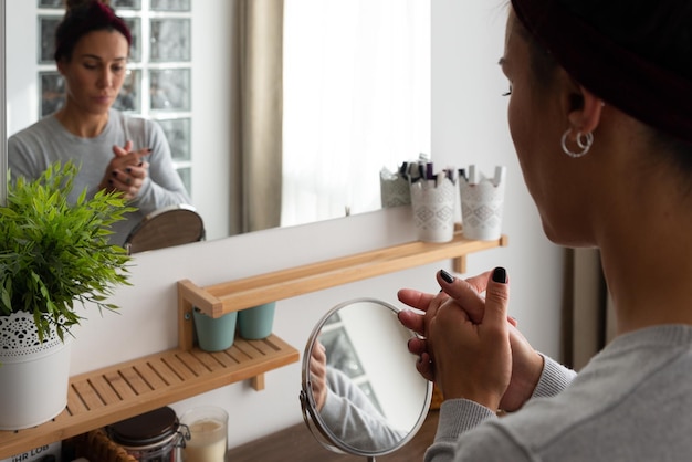 Photo young woman applying cream to her hands