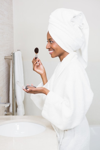 Young woman applying makeup on face