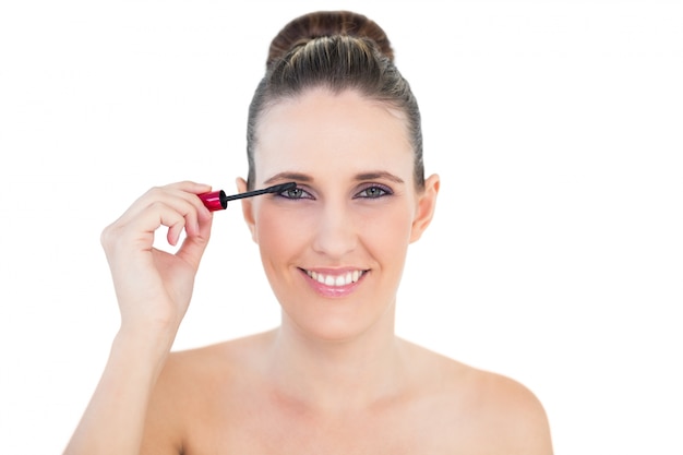 Photo young woman applying mascara