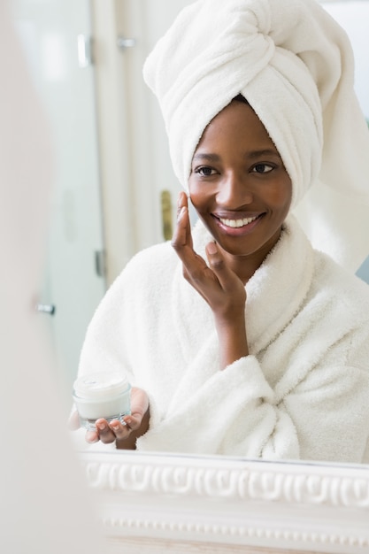 Young woman applying moisturizer