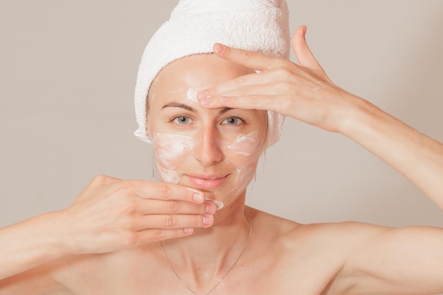 Young woman applying moisturizer