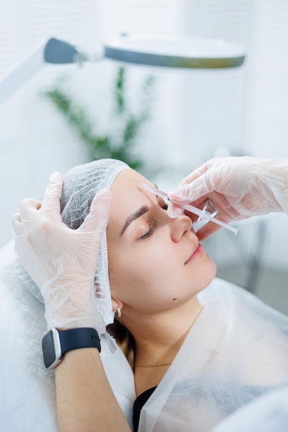 A young woman at an appointment with a beautician beauty injections for the face Treatment procedure at a dermatologist