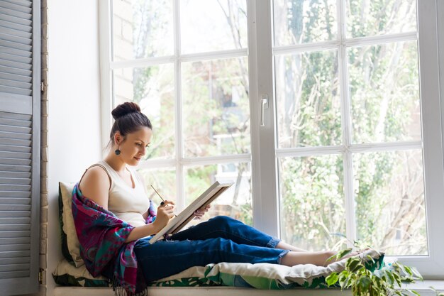 Young woman artist painting at home