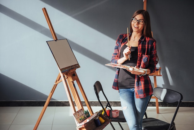 Young woman artist painting a picture