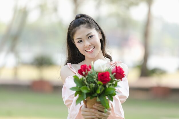 молодая женщина азиатских девушка с розами красный улыбается hoppy в день Святого Валентина