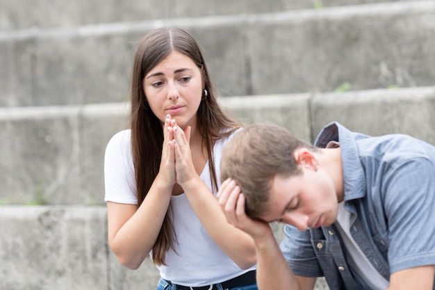 Young woman asking for forgiveness to boyfriend. Relationship problems solving concept.