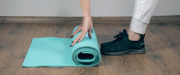 Young woman assembles exercise mat