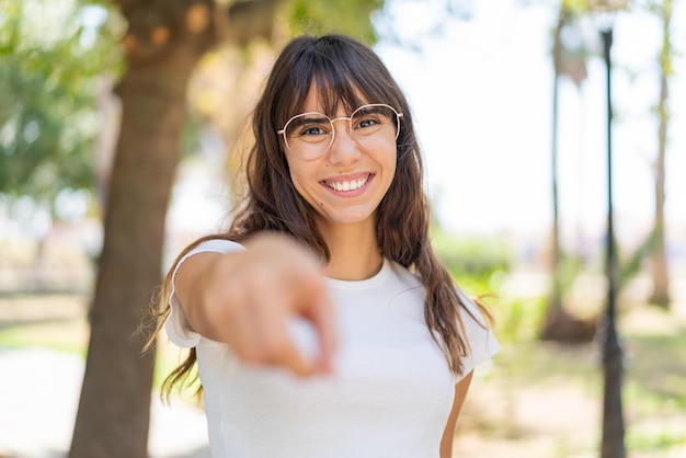 写真 屋外の若い女性が自信に満ちた表情であなたに指を指す