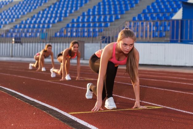 Atleta della giovane donna alla posizione di partenza pronta ad iniziare una gara.