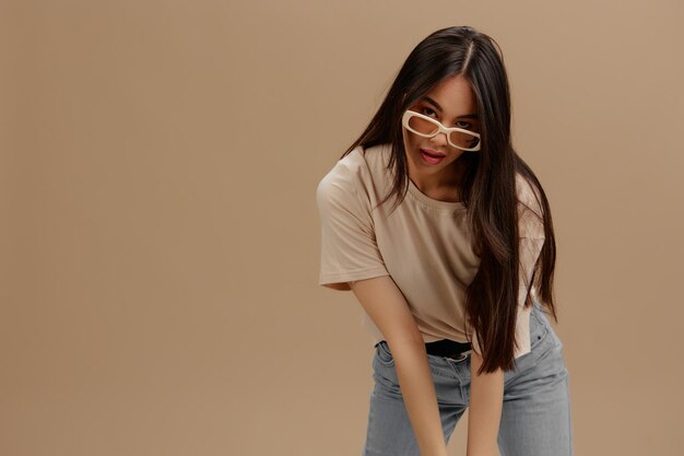 young woman attractive look charmin dark glasses in a tshirt beige background high quality photo