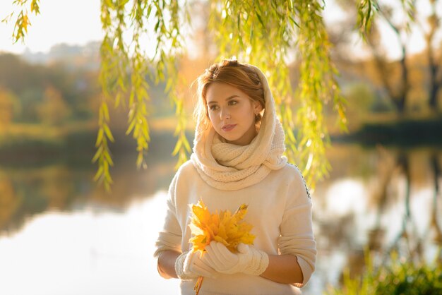 Young woman in a autumn park. Lady with a leafs.