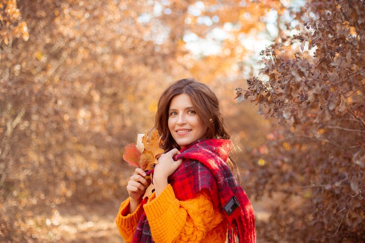 Photo a young woman in an autumn park in an orange sweater