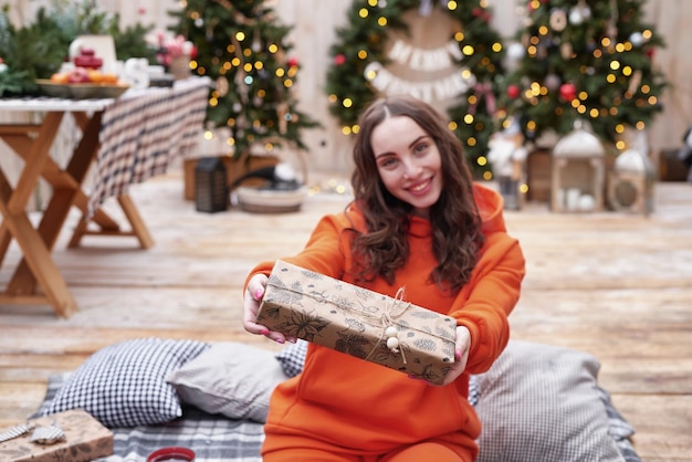 Young woman on background of Christmas tree with gifts outdoor Backyard decoration new year