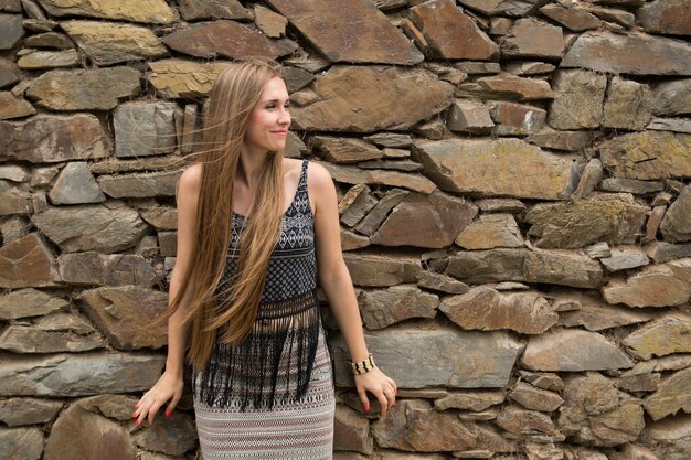 Foto giovane donna sullo sfondo del vecchio muro di pietra