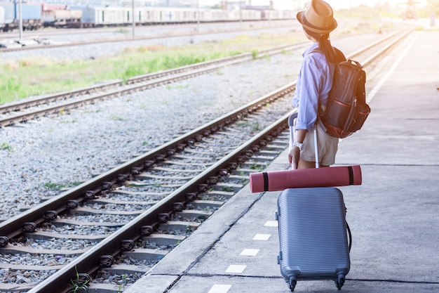 写真 若い女性のバックパッカー駅で、計画旅行のための地図を見て。