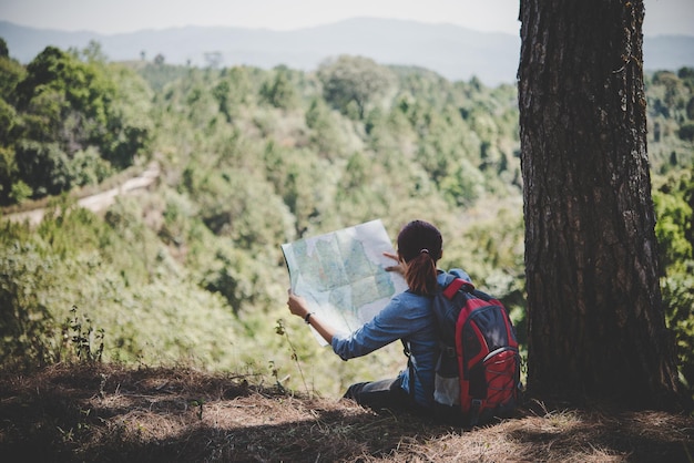 写真 若い女性のバックパッカーハイカーが地図を読んで ハイキング旅行に行く場所を探して アドベンチャーホリデー