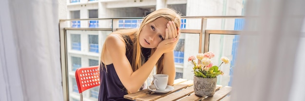 建物に悩まされているバルコニーの若い女性は、騒音の概念の大気汚染の外で働いています