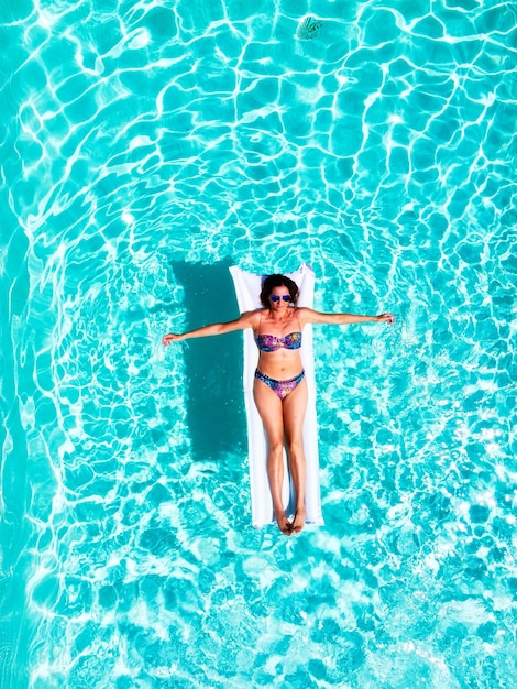 young woman bathing in a pool, in summer