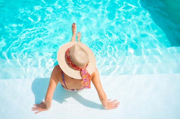 young woman bathing in a pool, in summer