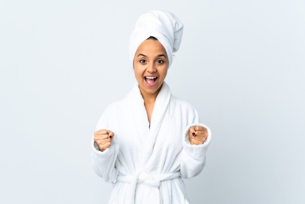 Young woman in bathrobe isolated celebrating a victory in winner position