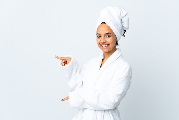 Young woman in bathrobe isolated pointing finger to the side and presenting a product