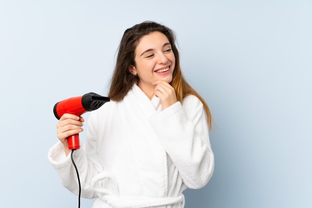 Young woman in a bathrobe with hair hairdryer thinking an idea and looking side
