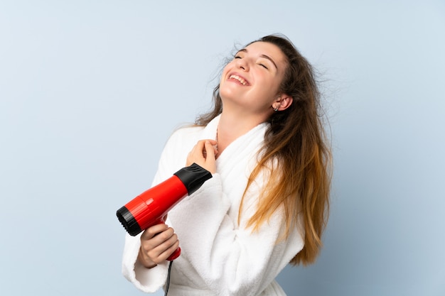 ヘアドライヤーとバスローブの若い女性