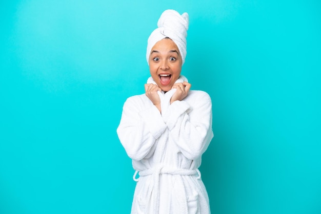 Young woman in a bathrobe with towel isolated on blue background