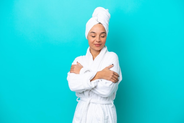 Young woman in a bathrobe with towel isolated on blue background