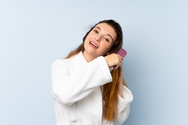 Young woman in a bathrobe with with hair comb