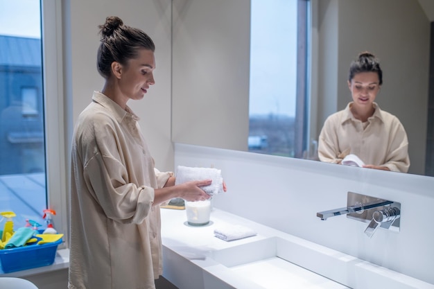 Young woman in the bathroom doing some cleaning