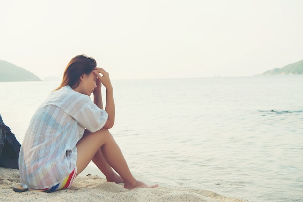 Young woman on the beach and be sad concept