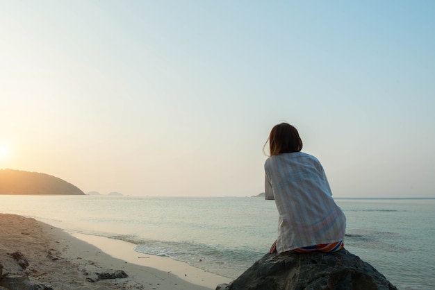 Giovane donna sulla spiaggia, concetto triste