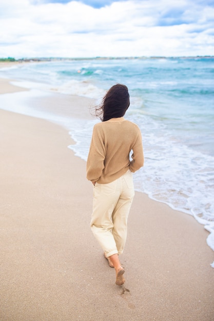 Young woman on the beach in the storm